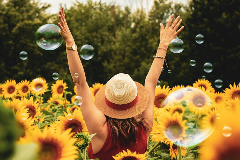 Eine glückliche Frau im Sonnenblumenfeld